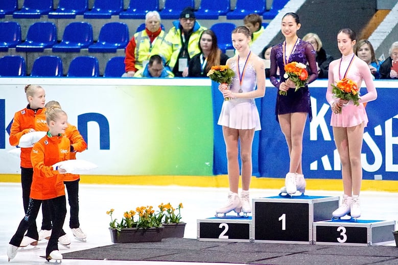 Emmy stands at the top of a podium to receive her first international gold medal. Won representing U.S. Figure Skating at the 2017 Challenge Cup in The Hague, Netherlands.